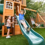 KidKraft Ridgemoor Perch Wood Swing Set with Playhouse, Rock Wall, and Tunnel Slide - Image 2